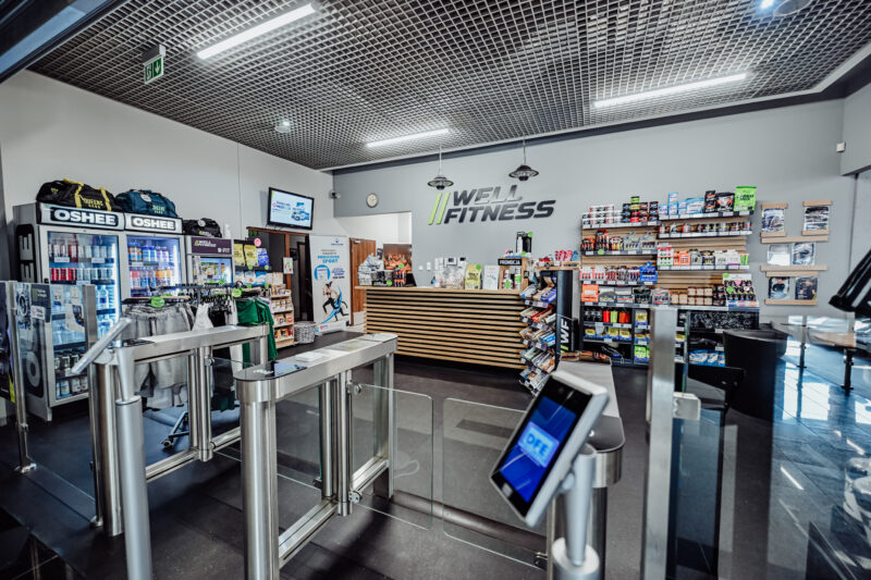 Wejście do siłowni – recepcja i bramki Well Fitness Jelenia Góra