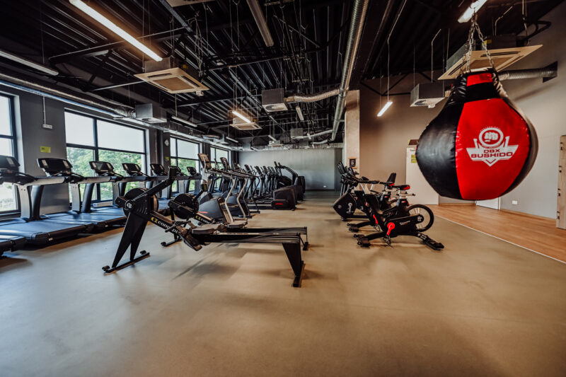 Wioślarze, worek bokserski i część strefy cardio w siłowni Żary