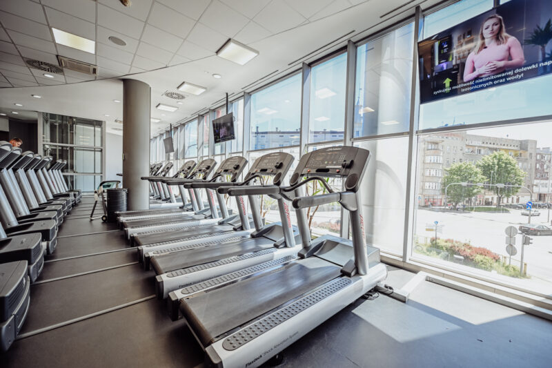 Bieżnie ustawione przy oknach – jasna przestrzeń cardio w Well Fitness Legnica Galeria Ferio.