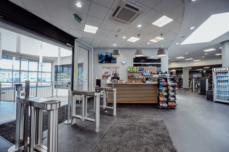 Recepcja i wejście do siłowni Well Fitness Legnica Galeria Ferio – bramki wejściowe.