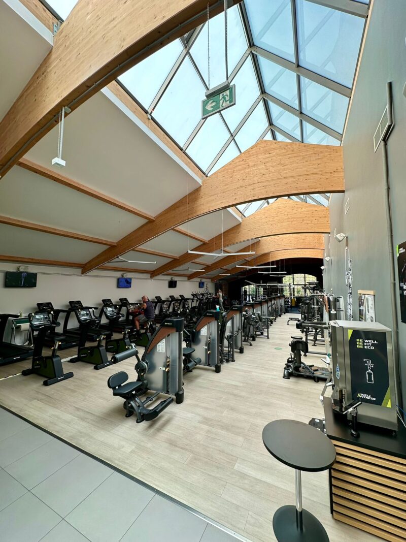 Strefa cardio w Well Fitness Wrocław Tęczowa – bieżnie, rowerki i orbitreki obok maszyny Well Hydrated