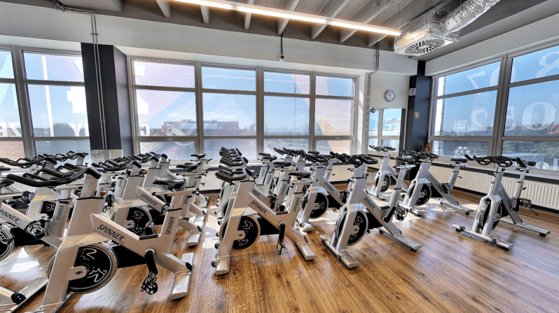 Sala z rowerkami spinningowymi do zajęć indoor cycling.