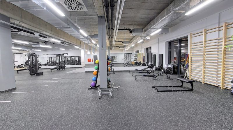 Sala z lustrem, piłkami oraz innym obciążeniem do ćwiczeń wydolnościowych.