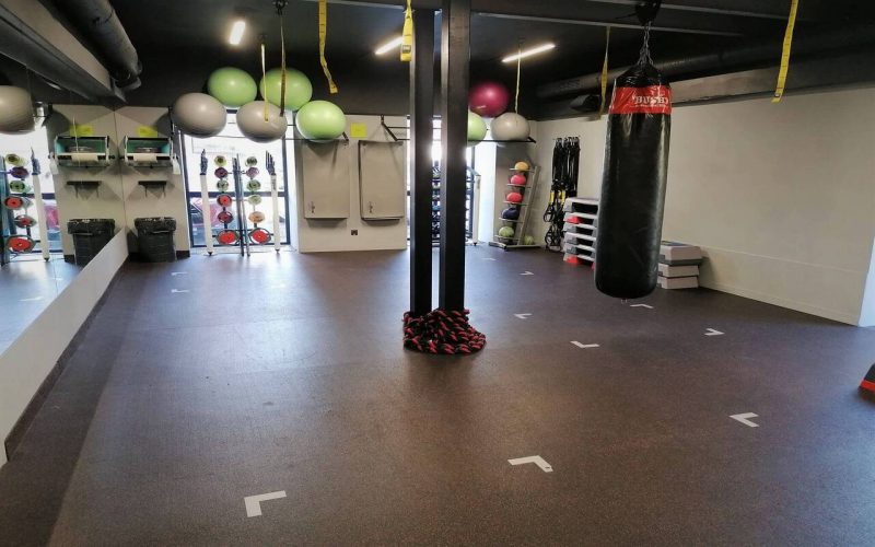 Sala do treningu funkcjonalnego. Na środku stoi słup z liną, pod ścianą piłki oraz akcesoria do ćwiczeń.