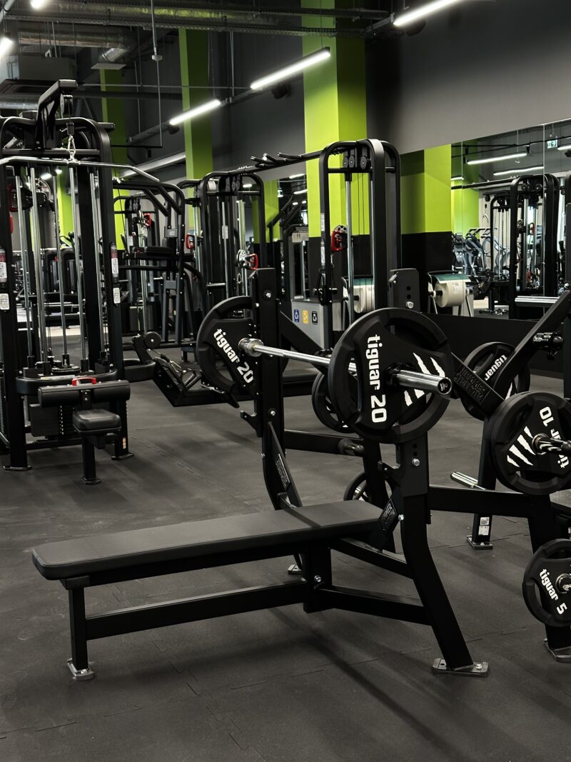 Ława prosta ze sztangą i obciążeniami – strefa wolnych ciężarów Well Fitness Wrocław Astra.