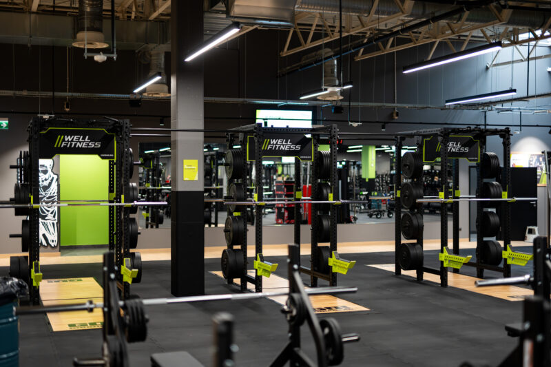 Główna strefa treningowa siłowni Well Fitness Piaseczno z maszynami i wolnymi ciężarami