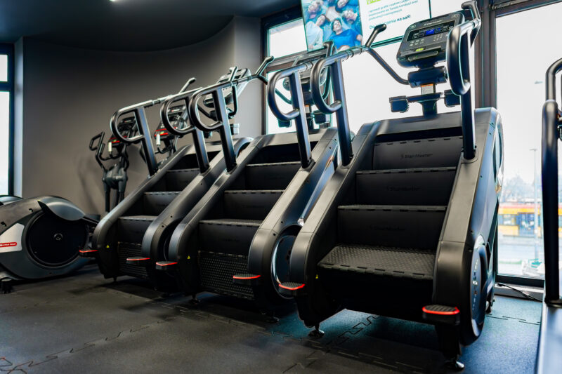 Schody treningowe – sprzęt do poprawy kondycji i wytrzymałości Strefa treningowa z maszyną schodową do cardio