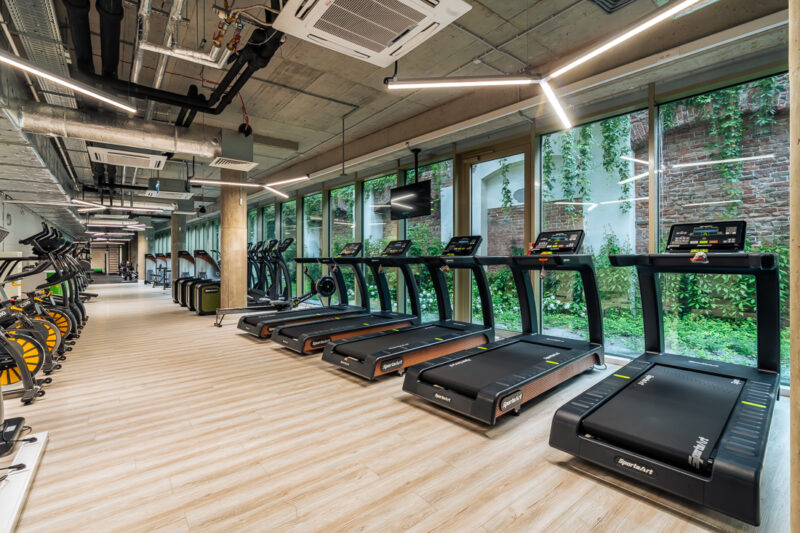 Strefa cardio przed panoramicznymi szybami – siłownia Warszawa Browary Warszawskie