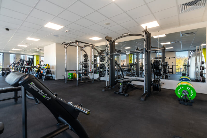 Strefa wolnych ciężarów z hantlami i sztangami w Well Fitness Łódź – Brama Miasta