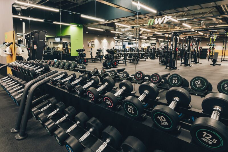 Hantle i wolna przestrzeń do ćwiczeń siłowych w klubie Well Fitness Gdańsk Oliwa
