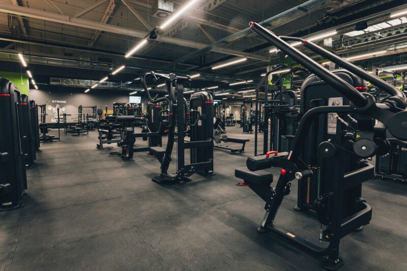 Rozbudowana strefa siłowa z maszynami i hantlami w Well Fitness Gdańsk Oliwa