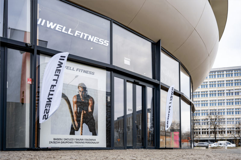 Wejście z zewnątrz: „Wejście do klubu Well Fitness Podwale OVO we Wrocławiu – widok z zewnątrz kompleksu OVO
