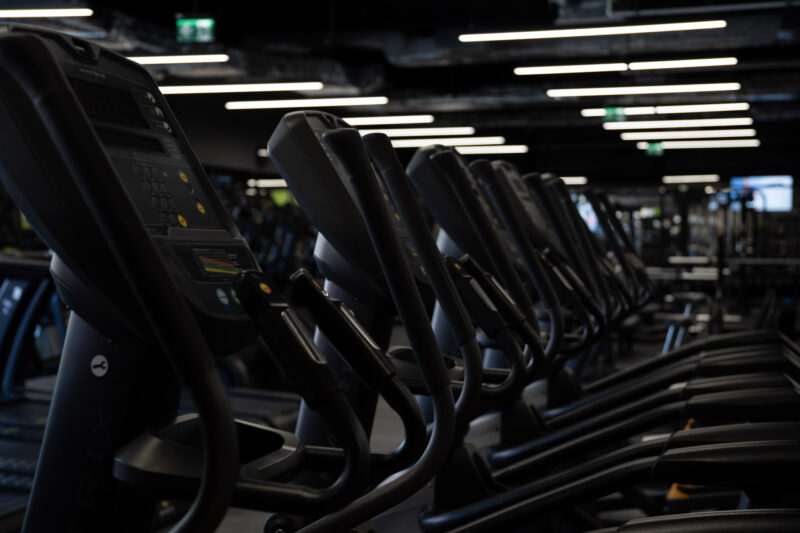 Detale paneli sterujących maszyn cardio Matrix, ukazujące nowoczesny interfejs i ergonomiczne uchwyty sprzętu.